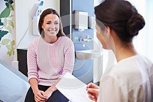 Female Patient And Doctor Have Consultation In Hospital Room photo