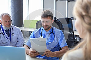 Female patient and doctors have consultation in hospital room