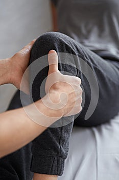 Female patient doing physical exercises with physiotherapist. Male therapist treating injured knee of young athlete.Post