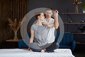 Female patient doing physical exercises with physiotherapist. Male therapist treating injured shoulder of young athlete