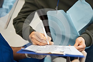 Female patient filing documents while sitting at the dentistry room