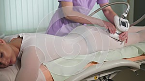 Female patient getting vacuum massage on her body in beauty salon.