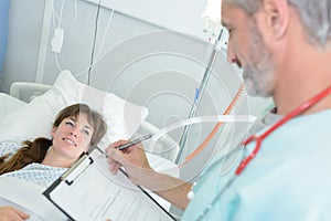 Female patient girl on bed talking to doctor