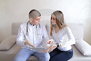 Female patient girl and male doctor osteopath with gadgets. Solv