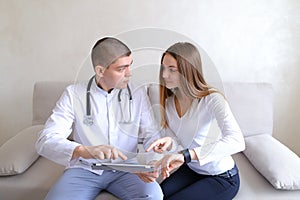 Female patient girl and male doctor osteopath with gadgets. Solv