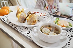 Female patient having lack of appetite regardless varied and delicious meal on the table