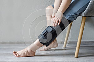 Female patient in knee brace support after injury and surgery. Healthcare and medical concept