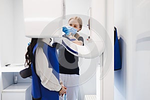 Female patient make a dental computer tomograph. The radiologist makes a CT scan of the jaw.