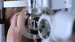 Female patient on medical attendance at the optometrist. Contemporary modern medical equipment.