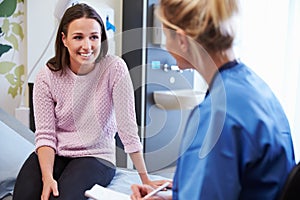 Female Patient And Nurse Have Consultation In Hospital Room