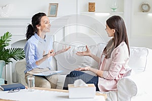 Female patient and psychotherapist having positive inspiring conversation