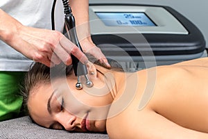 Female patient receiving electrotherapy therapy on face. photo