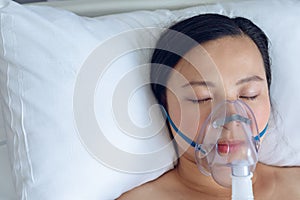 Female patient resting on bed in ward at hospital