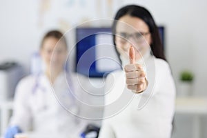 Female patient showing thumb up at doctor appointment closeup