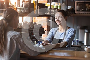 Female pay bill holding credit card using NFC modern technology