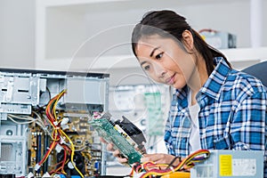 Female pc technician posing next to disassembled desktop