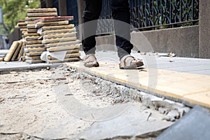Female pedestrians people is walking on a footpath walkway under construction and stacked cobblestone block or renovation,damaged