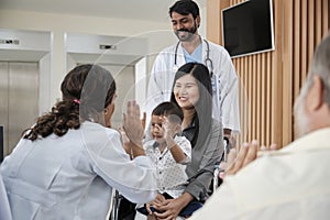 Female pediatric doctor teasing boy for examination at hospital.