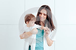 Female Pediatrician Holding Happy Baby for Examination