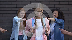 Female peers pointing fingers desperate schoolgirl, college teasing condemnation