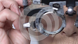 Female pensioner checking vision through phoropter, ophthalmology examination