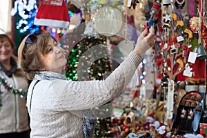 Female pensioner considering X-mas decorations at fair