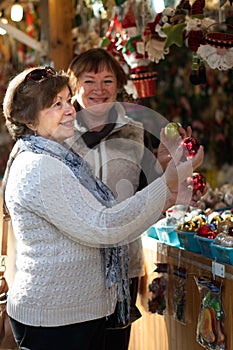 Female pensioners buying Christmas decorations at fair