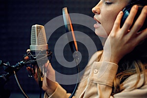 Female performer at micriphone, recording studio