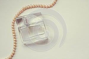 Female perfume on a white background with a pearl decoration