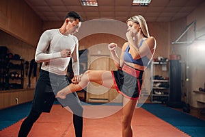 Female person makes kick in groin, self defense photo