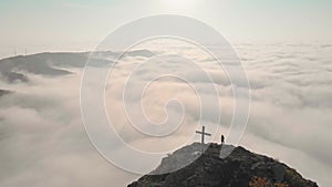 Female person silhouette standing above clouds on viewpoint of beautiful panorama
