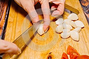 Female person slicing garlic for cooking