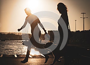 Female persor and her dog, golden retriever is running in a port during the sunset