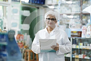 Female pharmacist checking stock inventory in pharmacy.