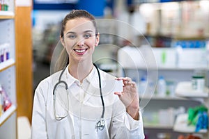 Female pharmacist holding a pill box in a pharmacy