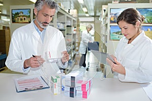 Female pharmacist and pharmacy technician posing in drugstore