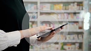Female pharmacist working in pharmacy with digital tablet and medicine, happy woman drug store, portrait consultant
