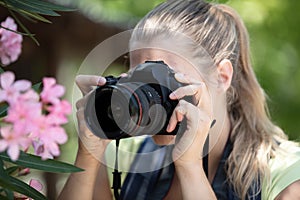 female photograph with camera taking macro picture flower