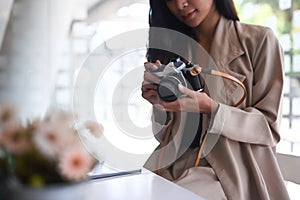 A female photographer checking photos in camera while sitting at her studio.