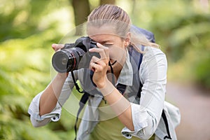 female photographer focusing camera in countryside