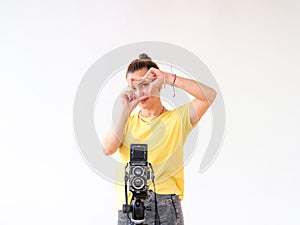 A female photographer frames a scene with her hands and fingers.