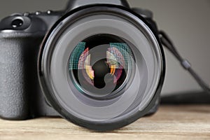 Female photographer holding professional camera on table