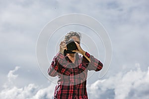 Female photographer in nature on a rock taking photos