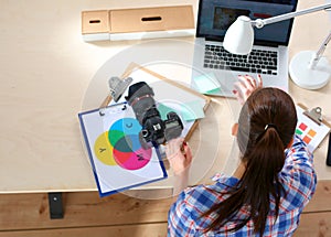 Female photographer sitting on the desk with laptop