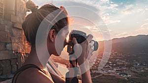 Female photographer, taking pictures of mountain landscape at sunset