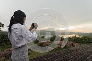 Female photographer taking pictures of the sunset.