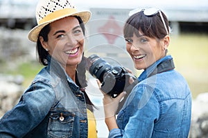 female photographers watching photos on new slr camera