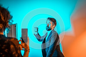 Female photographing a male posing holding his fist up