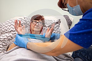 Female physical therapist helps senior woman exercises at home , Nurse helping senior woman exercise