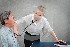 Female Physician Doctor is Examining Physical Symptom of Senior Patient in Examination Room, Practitioner Doctor Using Stethoscope